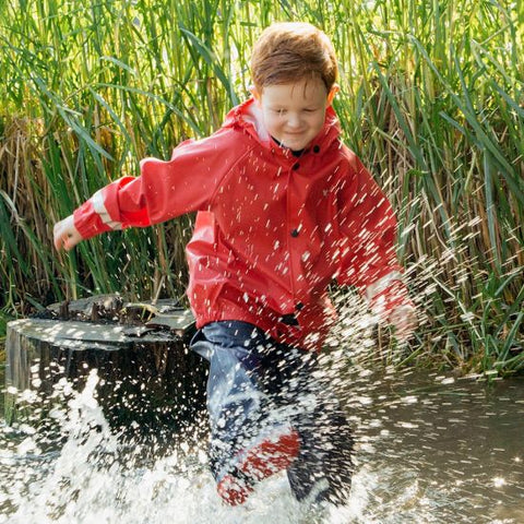 Muddy Puddles PU Rainwear worn by child splashing in a puddle