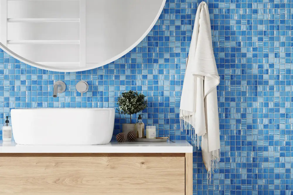 Photo d'une salle de bain, une commode en bois, un grand miroir, un lavabo, un grand mur bleu, une serviette blanche