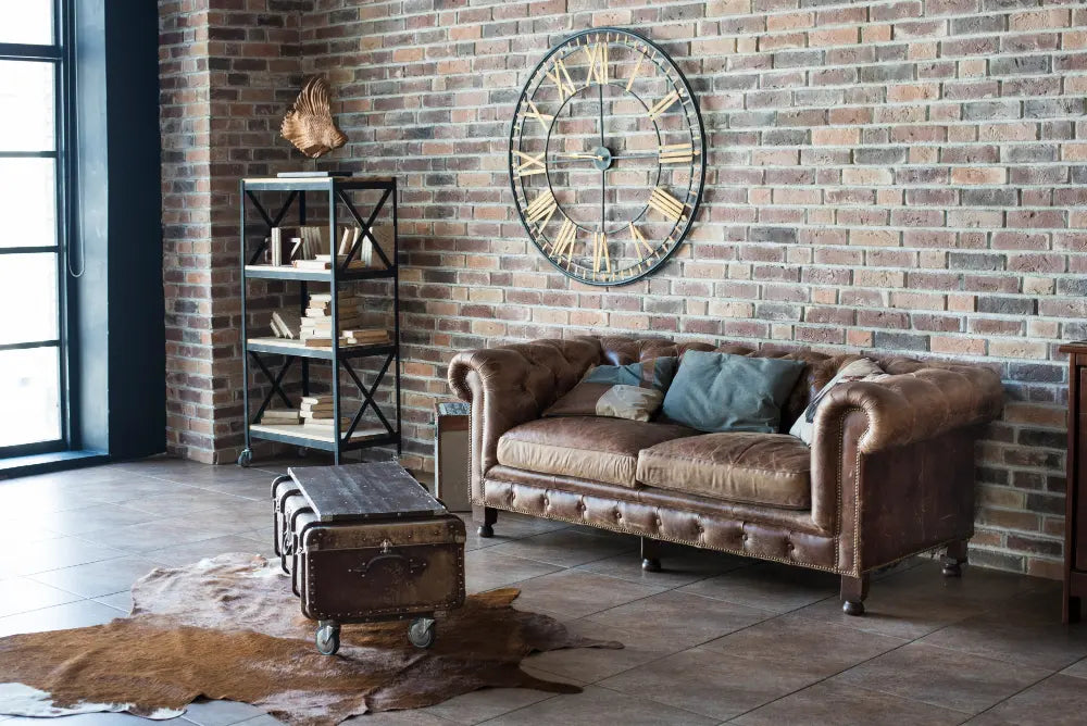 salon industriel, mur en brique, canapé en cuir, étagère en métal, tapis en vieille peau