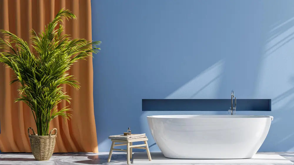 Photo d'une baignoire blanche avec un mur bleu, une plante verte, un sol blanc