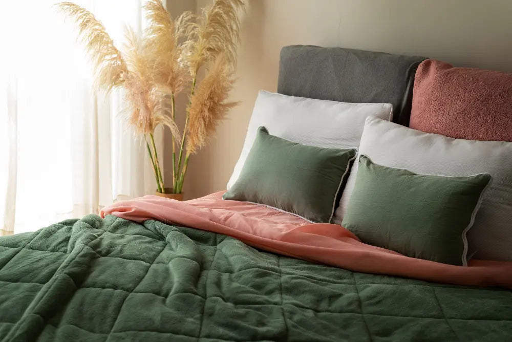 chambre à coucher avec un lit et un matelas, coussins et couettes vertes 