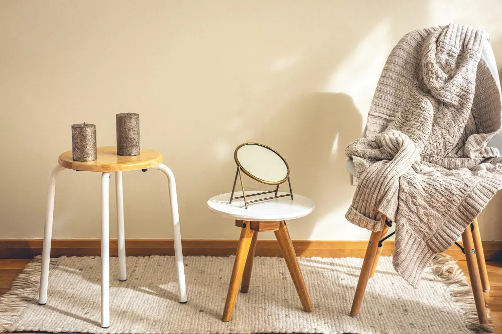 photo d'un bout de salon, un tabouret en bois, un tabouret en bois avec un miroir, un tapis beige au sol, un mur beige