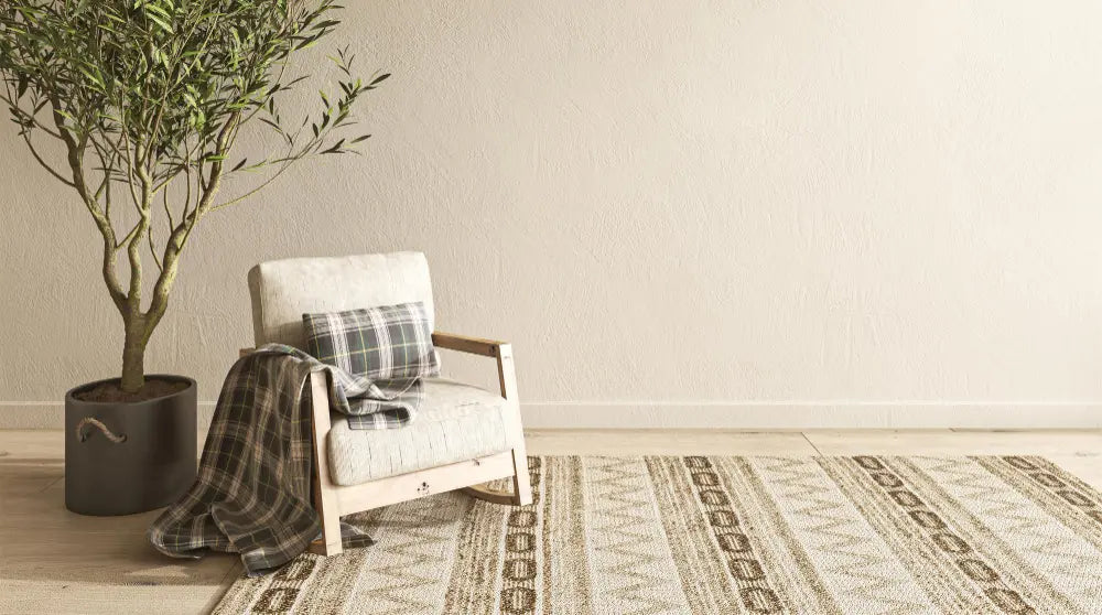 photo d'un fauteuil beige avec un plante verte, un tapis beige et des murs beiges