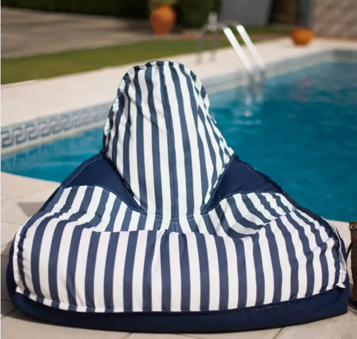 photo d'un pouf d'extérieur à rayure bleu près d'une piscine