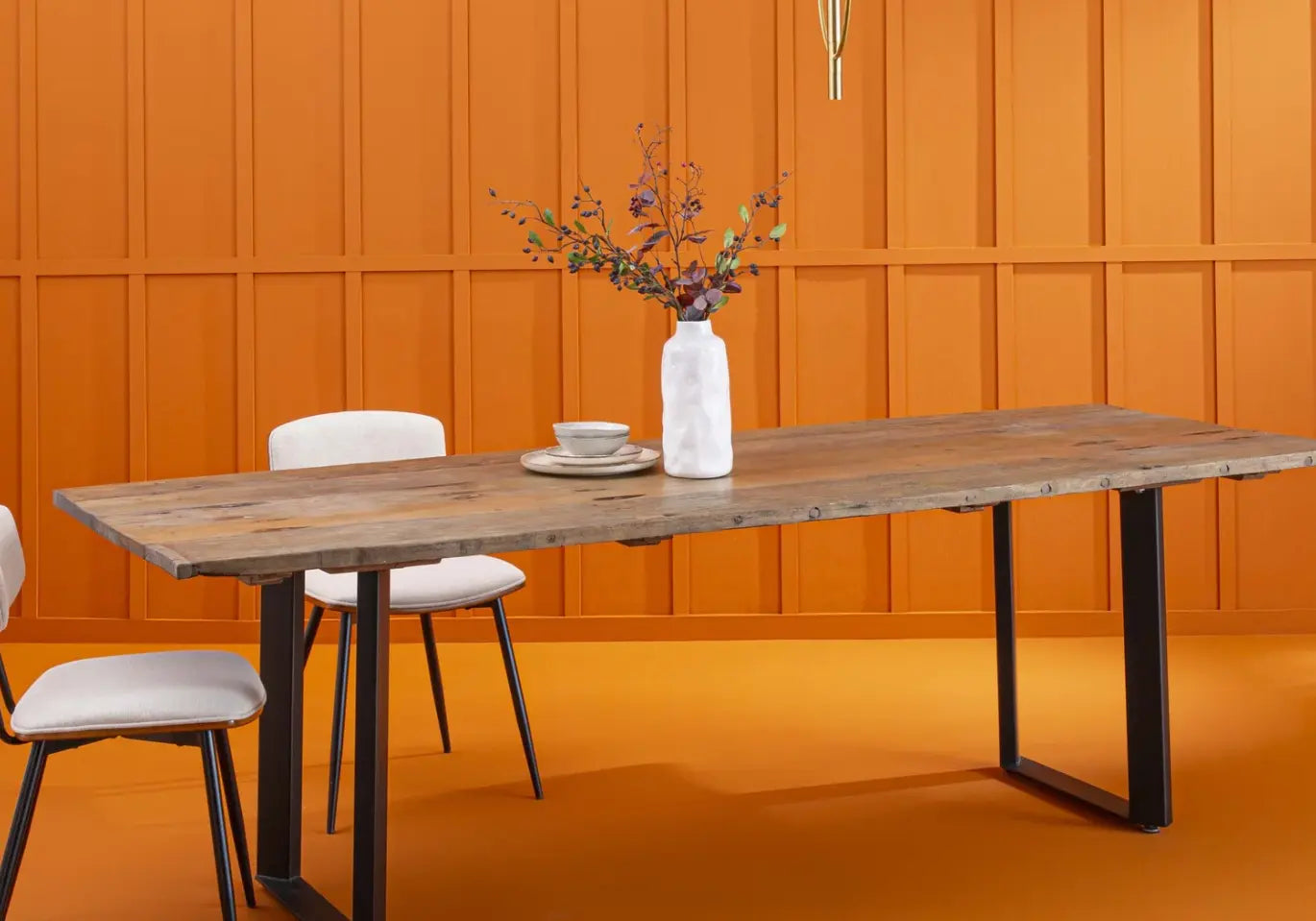 table en bois avec des pieds en métal et des chaises blanches