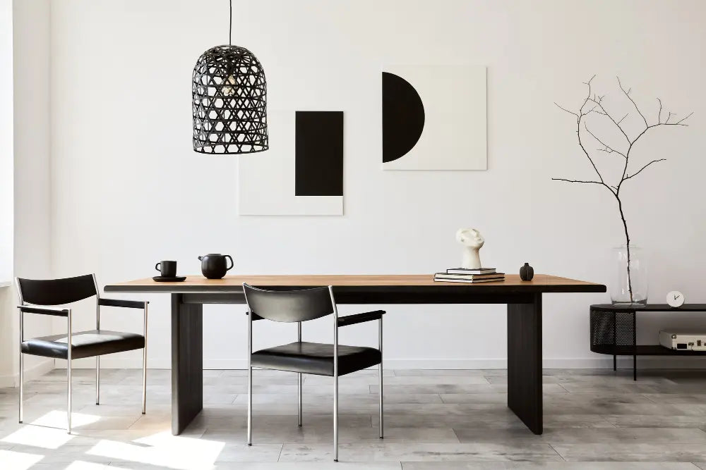 salle à manger moderne avec une table, deux chaises, une tasse, un mur blanc, une petite commode