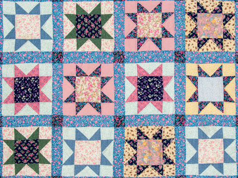 Image shows a traditional quilt made of 12 star quilt blocks made in pastel colors.