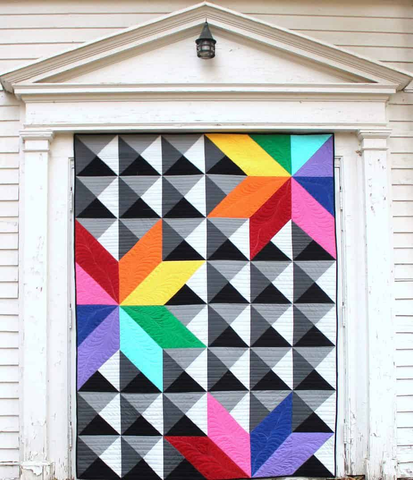 Photo shows Live Boldly Quilt Pattern displayed hanging in a door frame.