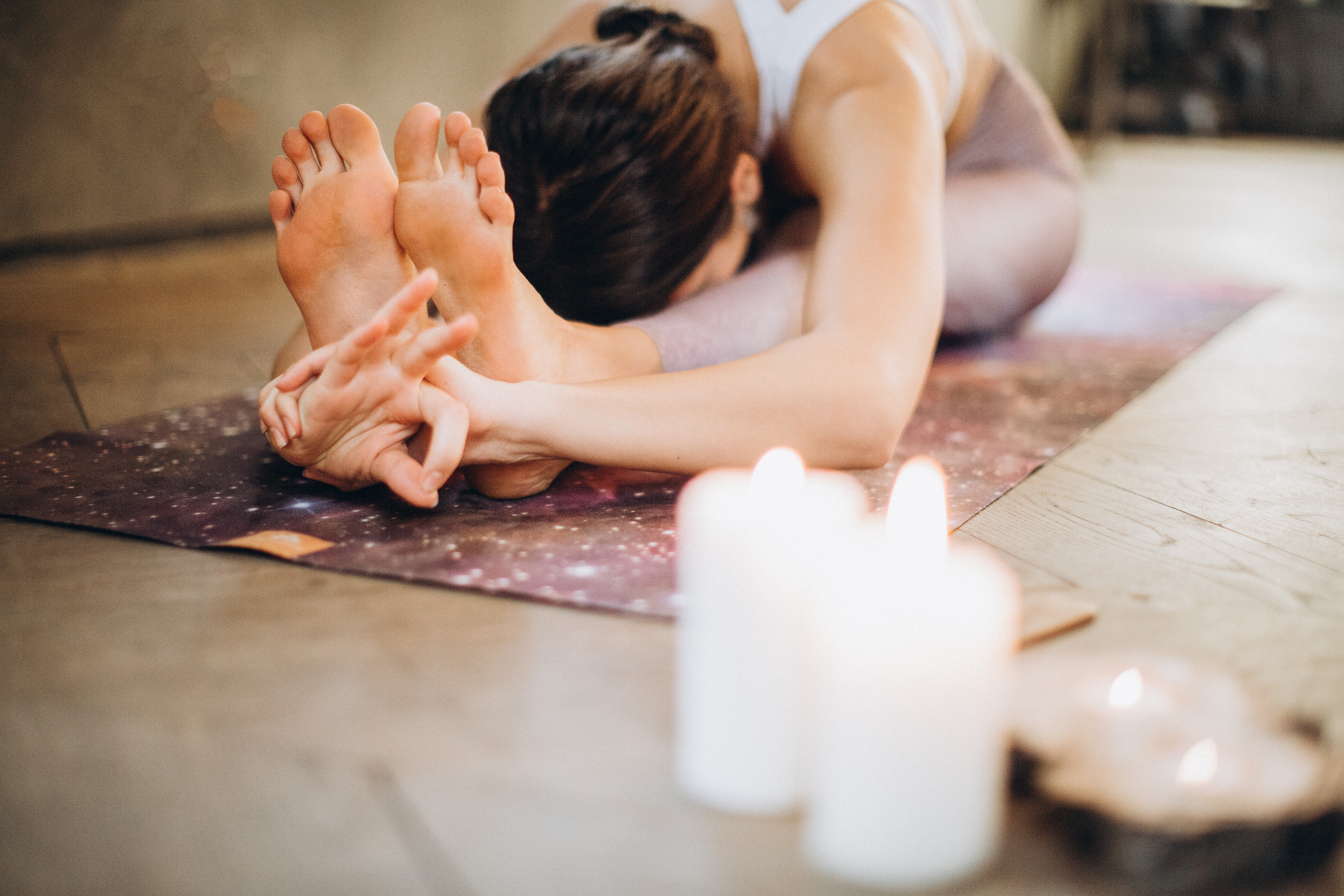 woman doing yoga with candles lit