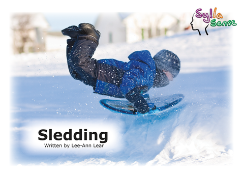 Cover page for the book titled "Sledding" showing a young boy in a blue snowsuit going over a snow pile on a blue sled