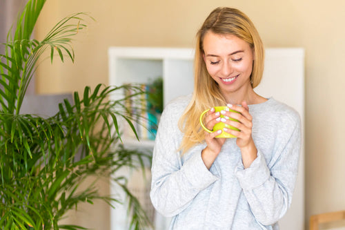 woman-looking-her-cup-coffee-nearby-plant (1).jpg__PID:eaa27ff4-1fbf-4288-8233-bd04d77cbdc5