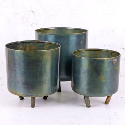 A trio of matching green, metal pots in three different sizes.