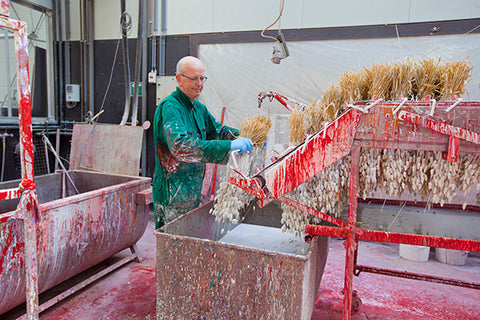 Hand painting bunches of dried flowers at the Lamboo production facility.