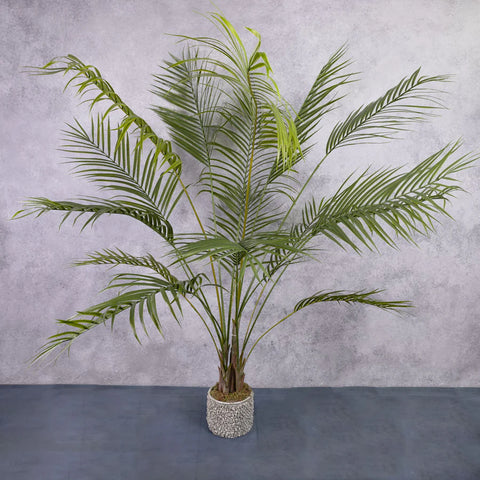 An artificial areca palm in a very small pot.