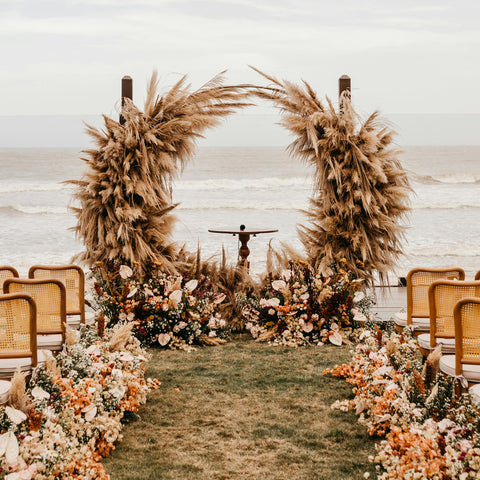 A stunning, circular pampas wedding alter at a coastal setting.