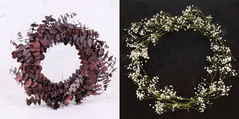 On the left, a wreath made of red, preserved eucalyptus, and on the right, a circle of preserved gypsophila stems being prepared to make a wreath.