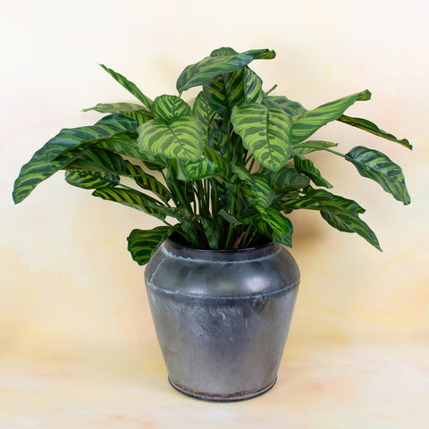 A faux plant in a grey pot