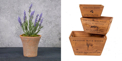 To the left is a faux lavender plant potted in a fluted terracotta pot, and on the right there is a stack of three different sized wooden crates that have been embellished with 'herbs de provence' text.