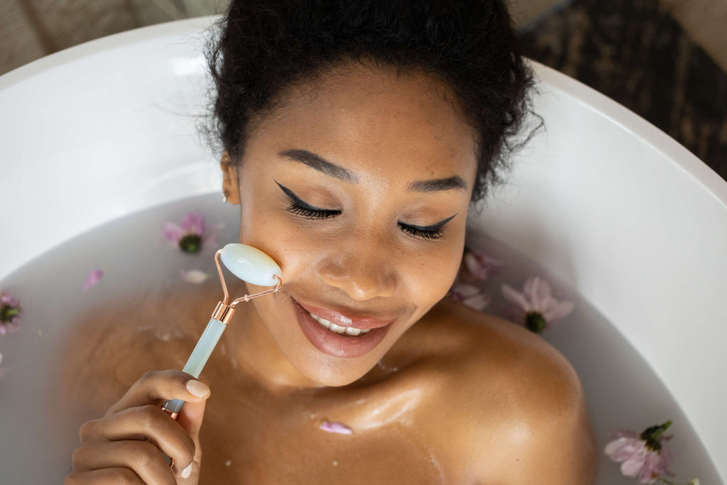 person taking a bath using jade roller on race