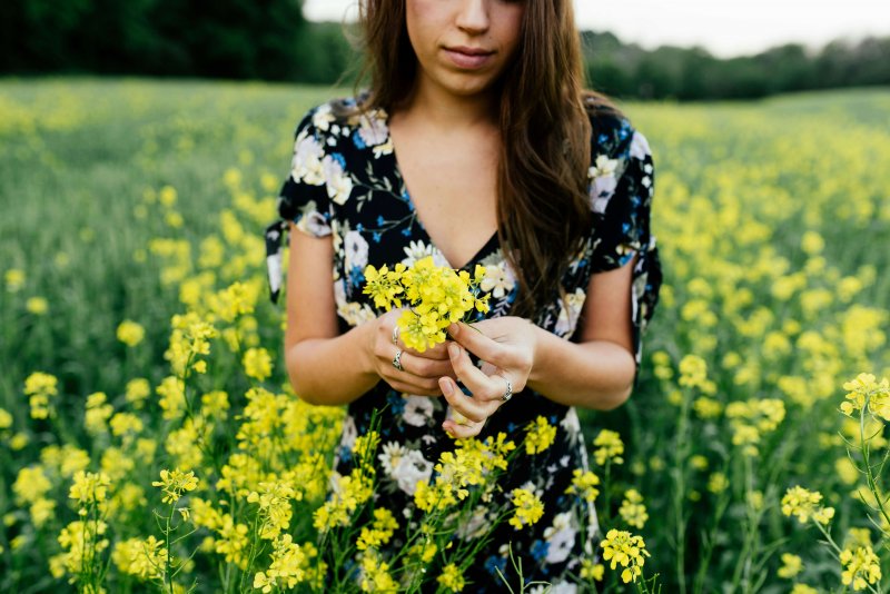 woman picking yellow spring flowers