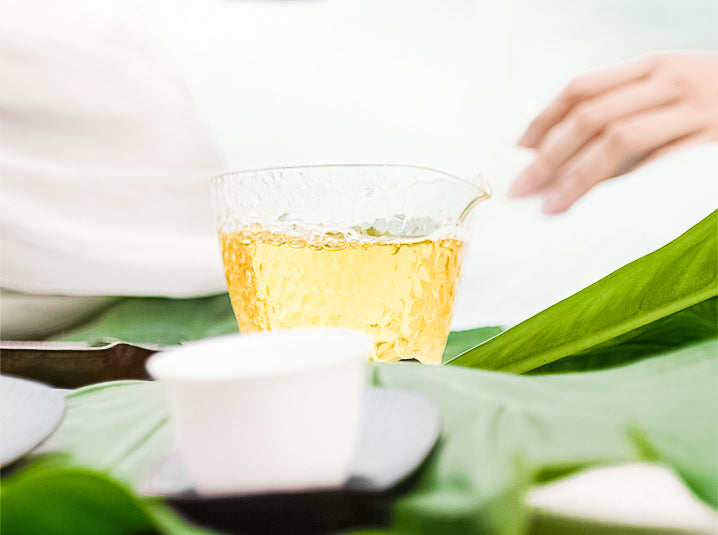 brewed caffeine-free Sobacha Buckwheat Tea in a glass beside white ceramic bowl