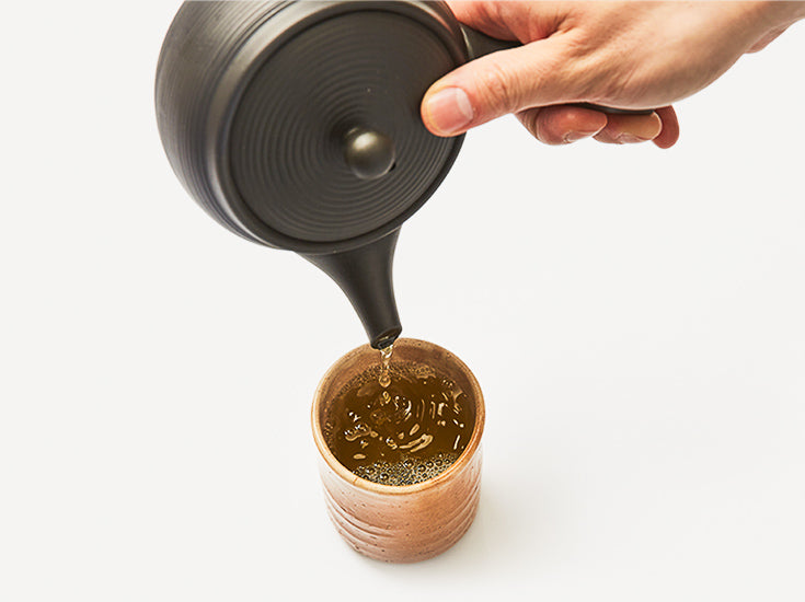 pouring brewed Genmaicha in a cup