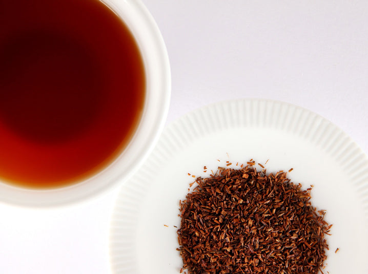 Brewed Rooibos Tea in a cup with Rooibos Tea leaves in a plate