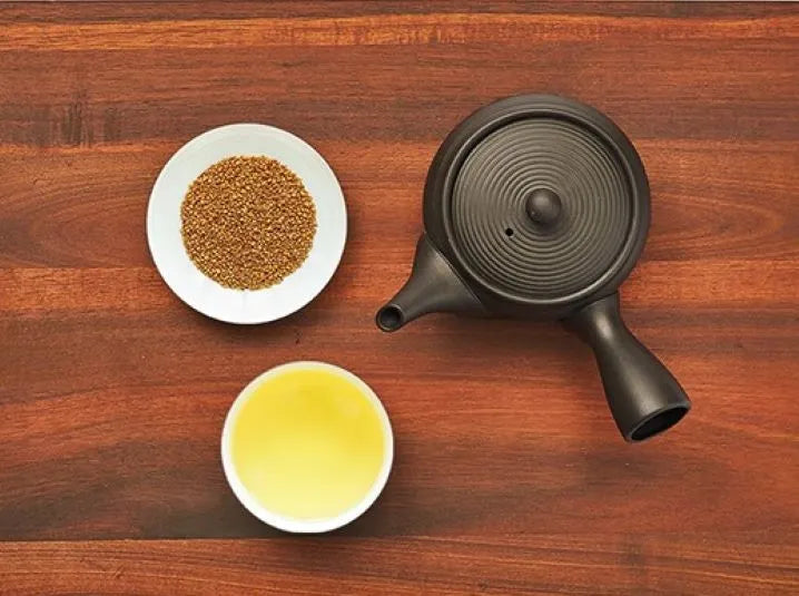 caffieine-free Japanese Sobacha buckwheat herbal tea on a white plate with a brewed cup and kyusu teapot on a brown wooden table