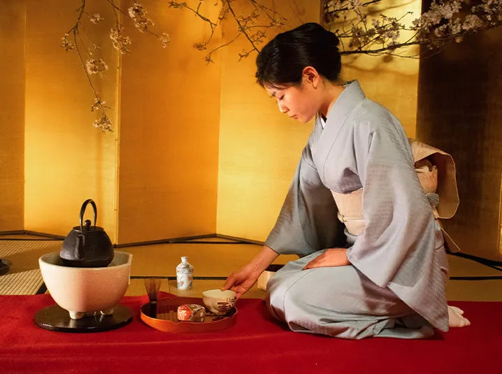 woman in kimono sitting in a traditional japanese tea house preparing matcha