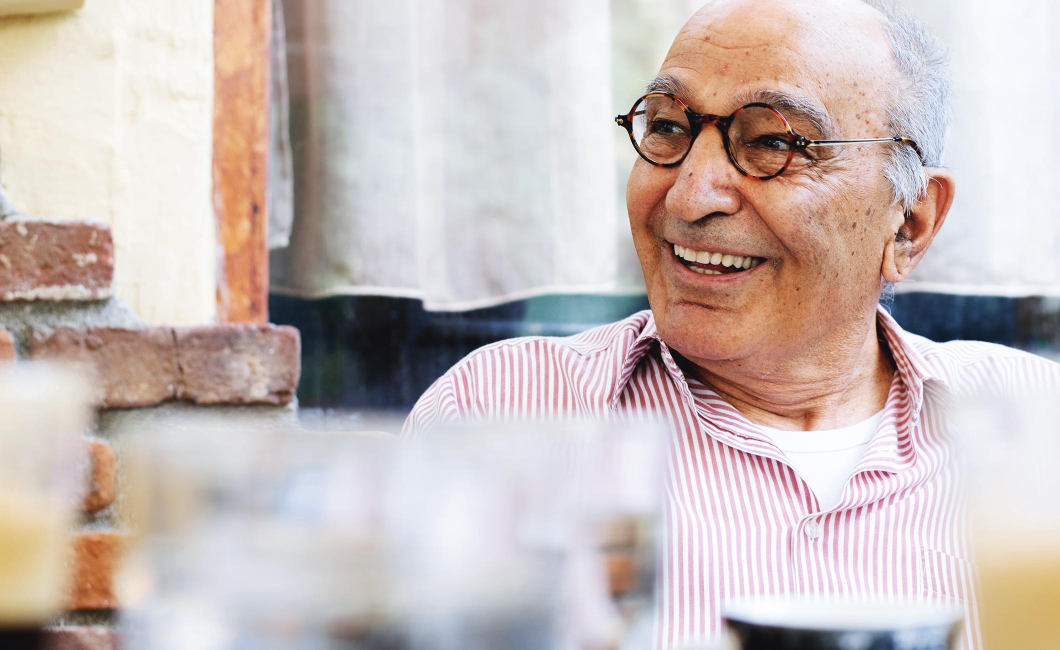 older man with glasses smiling 