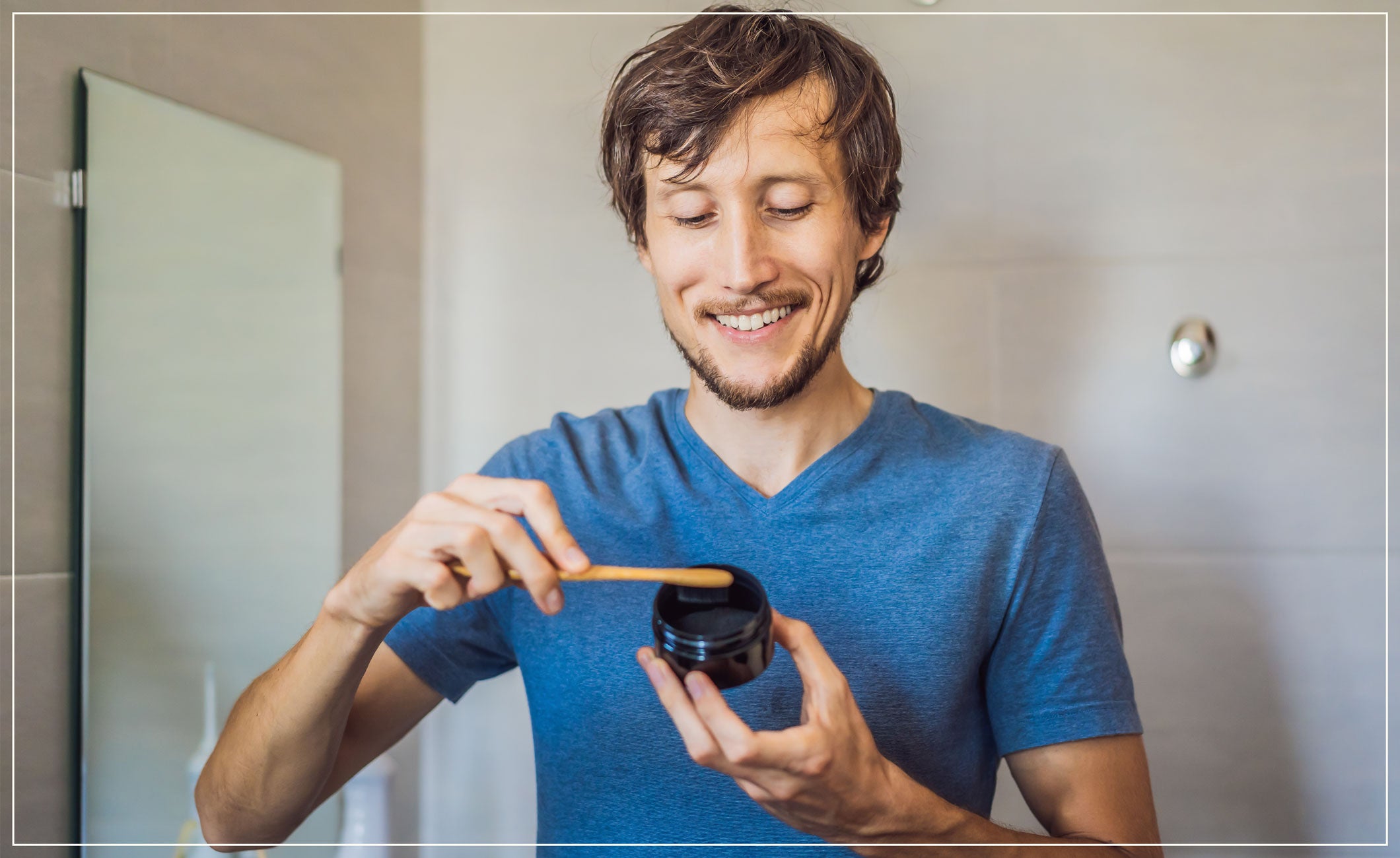 man smiling with a toothbrush and charcoal