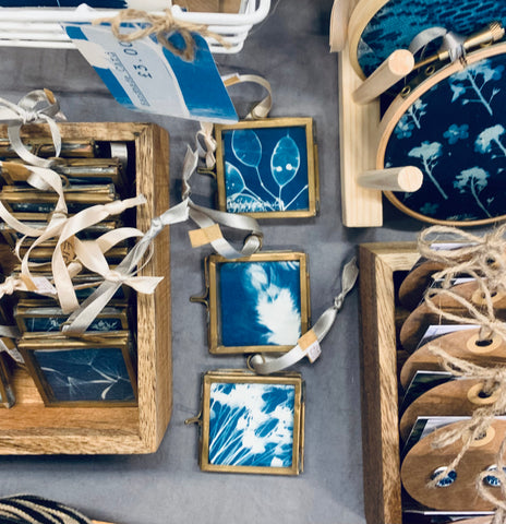 birds eye view of set up on Danielle's Stall of framed cyanotypes and earrings
