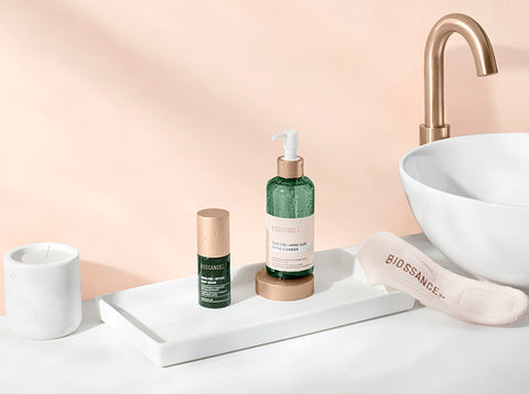 Amino Aloe Gentle Cleanser and Retinol Night Serum on a counter next to a sink