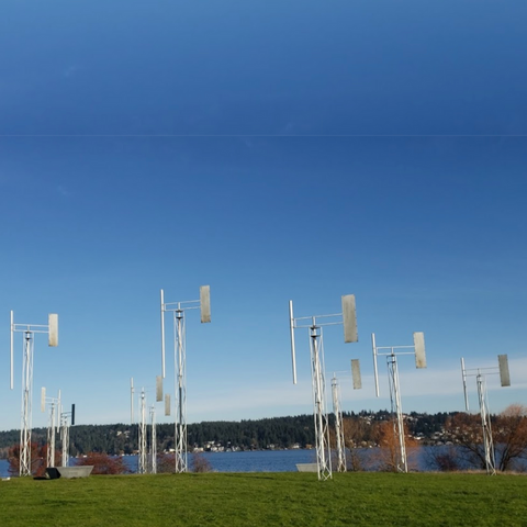 The Sound Garden installation near Magnuson Park in Seattle, featuring large wind-powered musical sculptures against a clear blue sky.