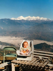 baby in front of mountain scenery