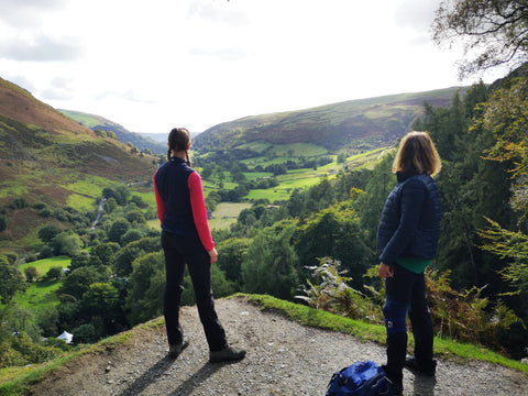 two hikers looking at the view in Wales of hills and trees during Mind Over Mountains reconnection walk