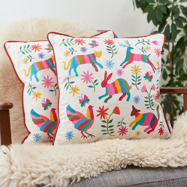Otomi Animals Cushions against a sheepskin on a chair. Designed by Mary Kilvert