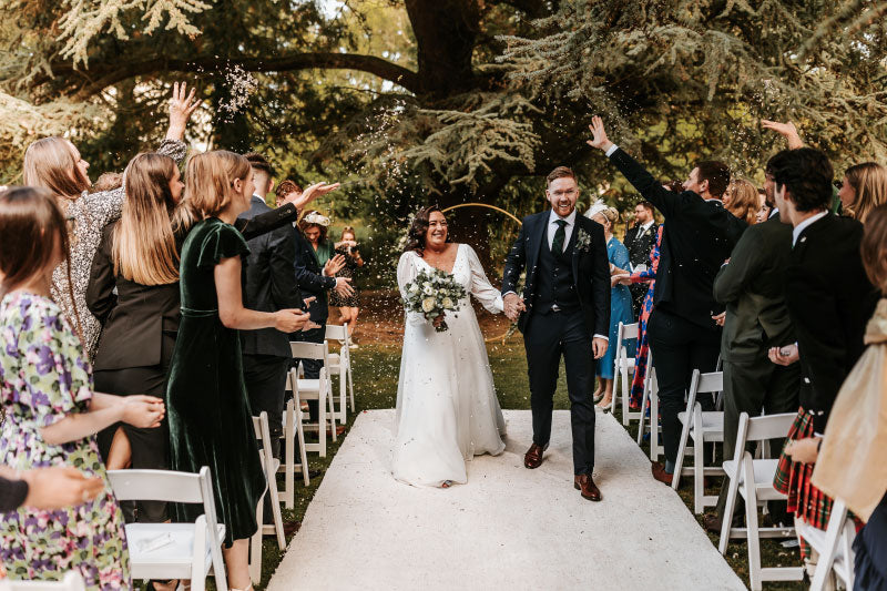 Newlyweds celebrating with petal confetti