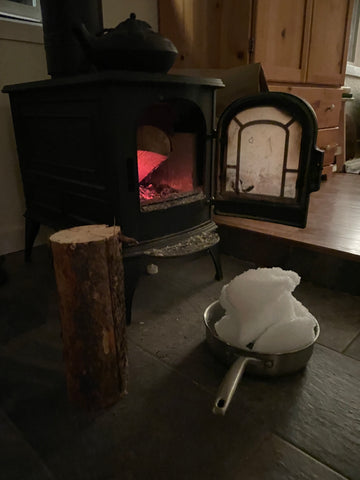 snow-filled pot melting by the fire