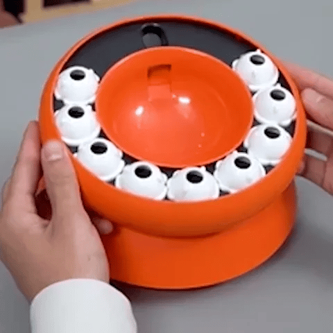 Vue de la gamelle anti-glouton chat croqpuzzle orange tenue Ă la main
