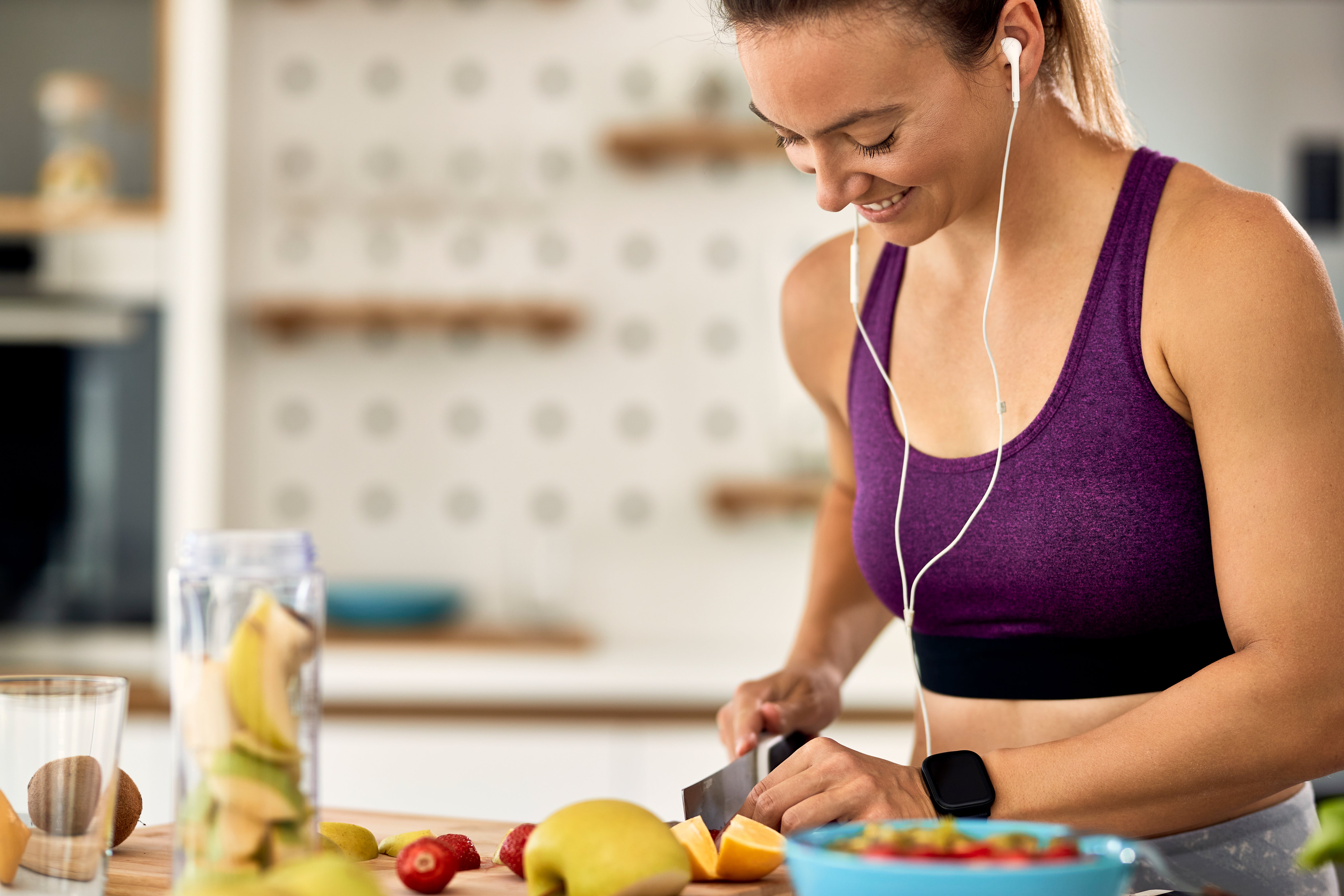 young-happy-athletic-woman-cutting-fruit-making-healthy-meal-kitchen.jpg__PID:a4fbed0b-530d-40d9-a1e0-49fcd1b7d983