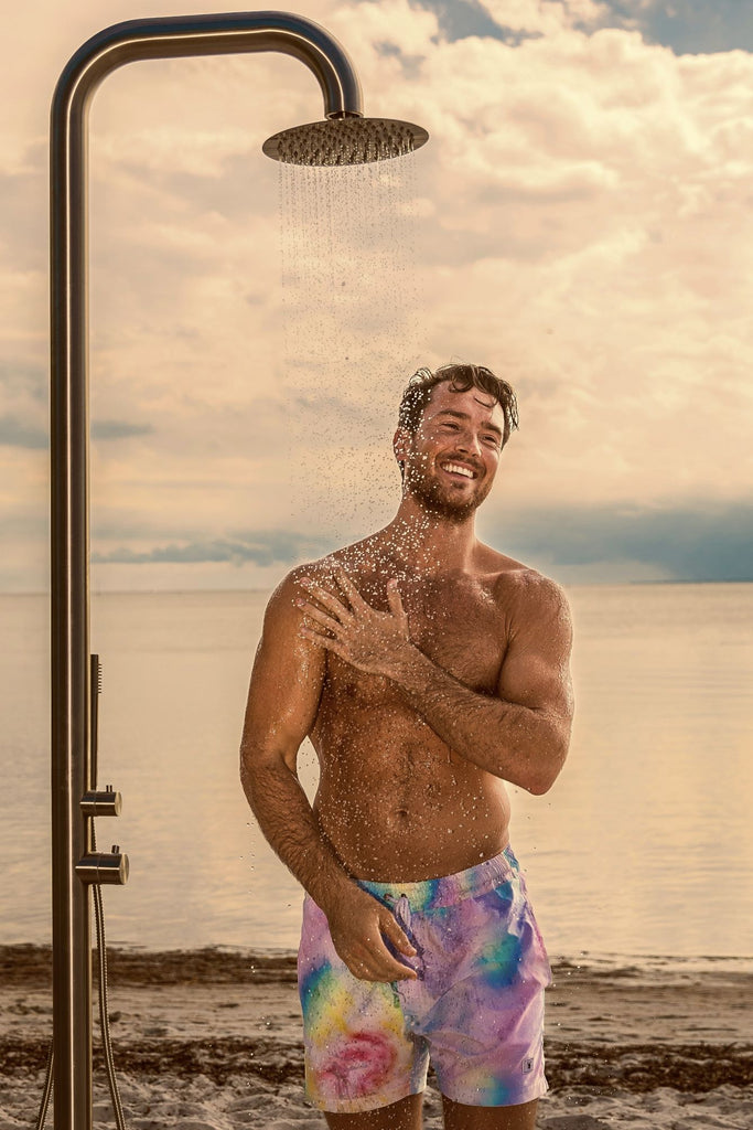 Athletic guy enjoying a Bold outdoor Shower