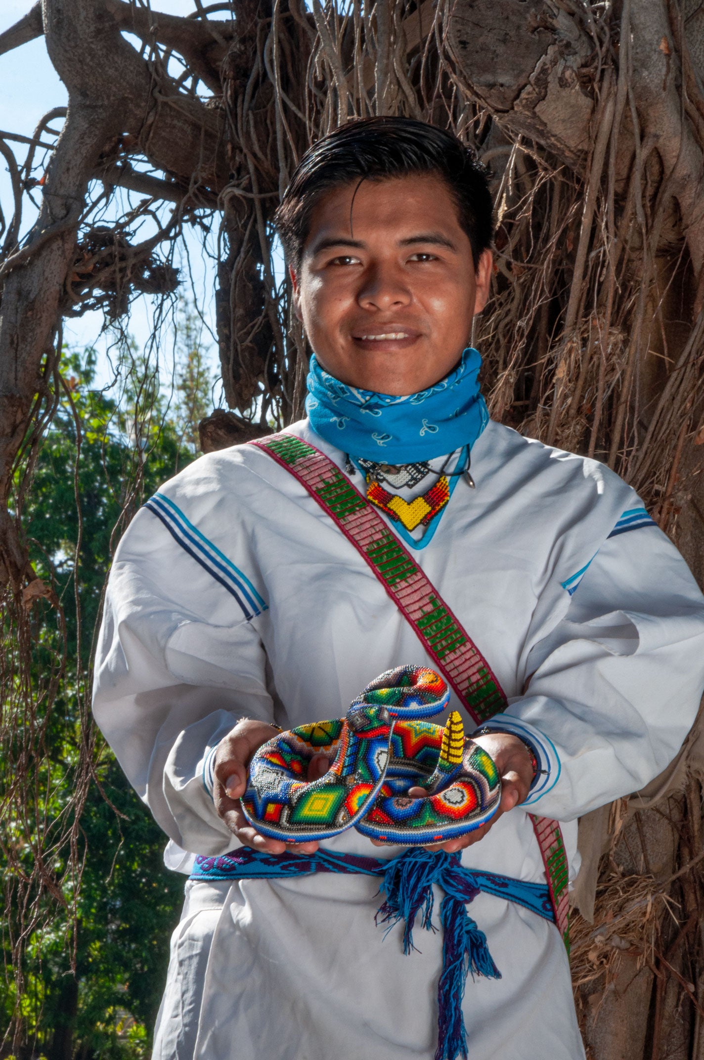Artesano-Huichol-con-una-artesania de serpiente-enchaquirada en-las-manos
