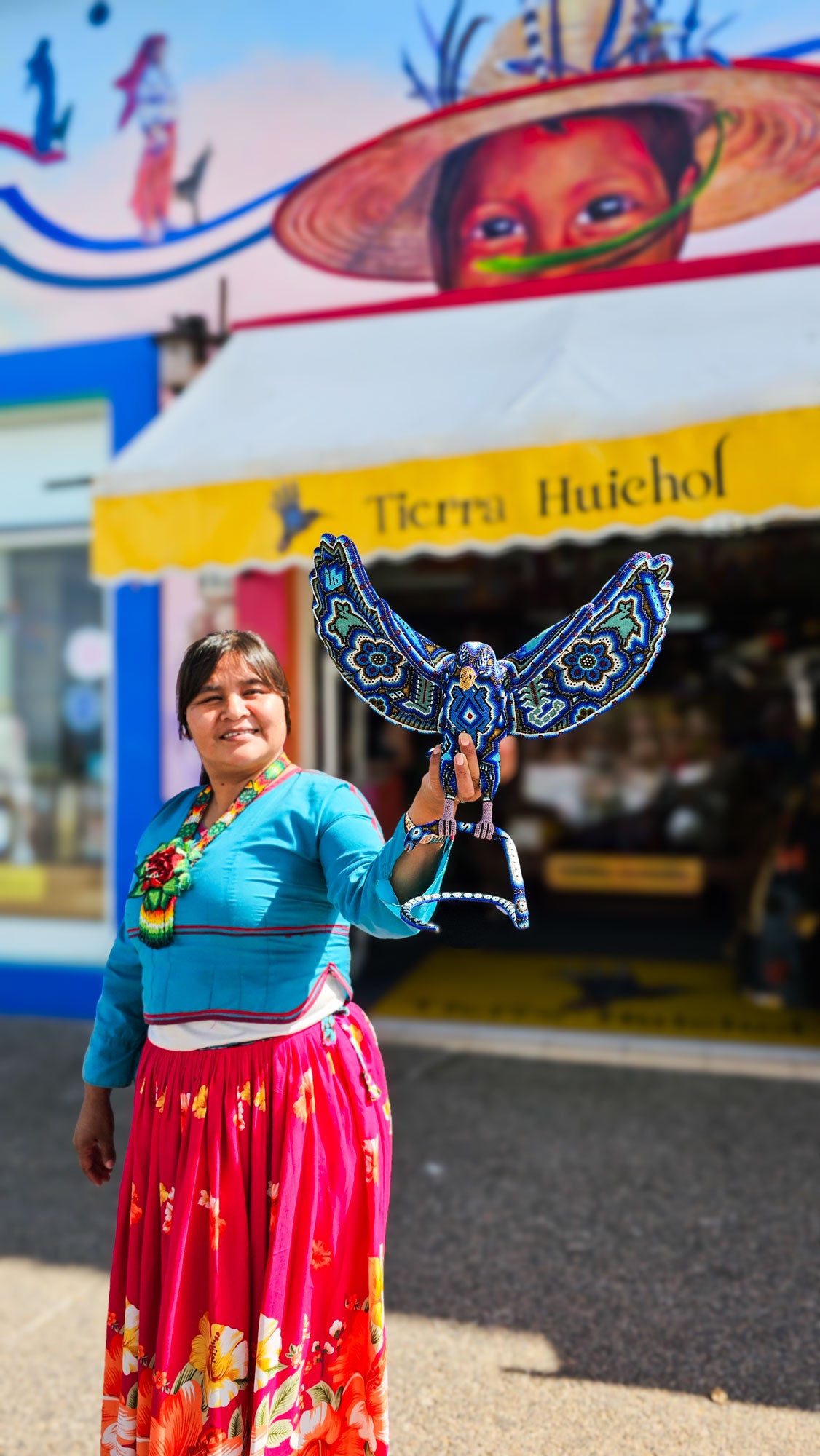 Mujer-hichol-con-una-aguila-en-arte-wixarika-en-la-mano