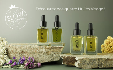 Les quatre flacons d'Huile Visage OPHÉO sont disposés dans un décor mélangeant roches et fleurs sauvages corses. Le logo du label Slow Cosmétique est également visible dans l'angle de mal photo.