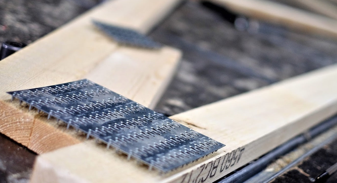 A close up of a roof truss with nailplates