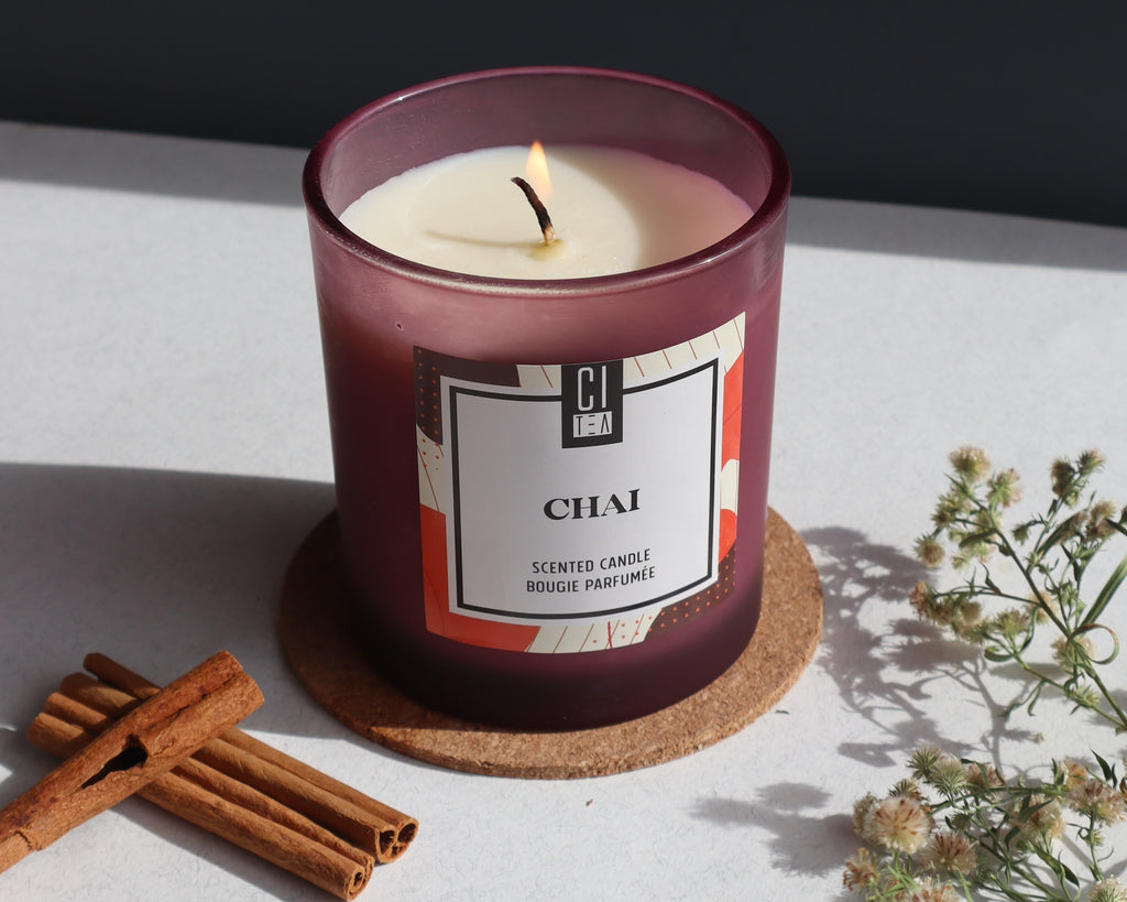 chai candle lightened, on a table with cinnamon sticks