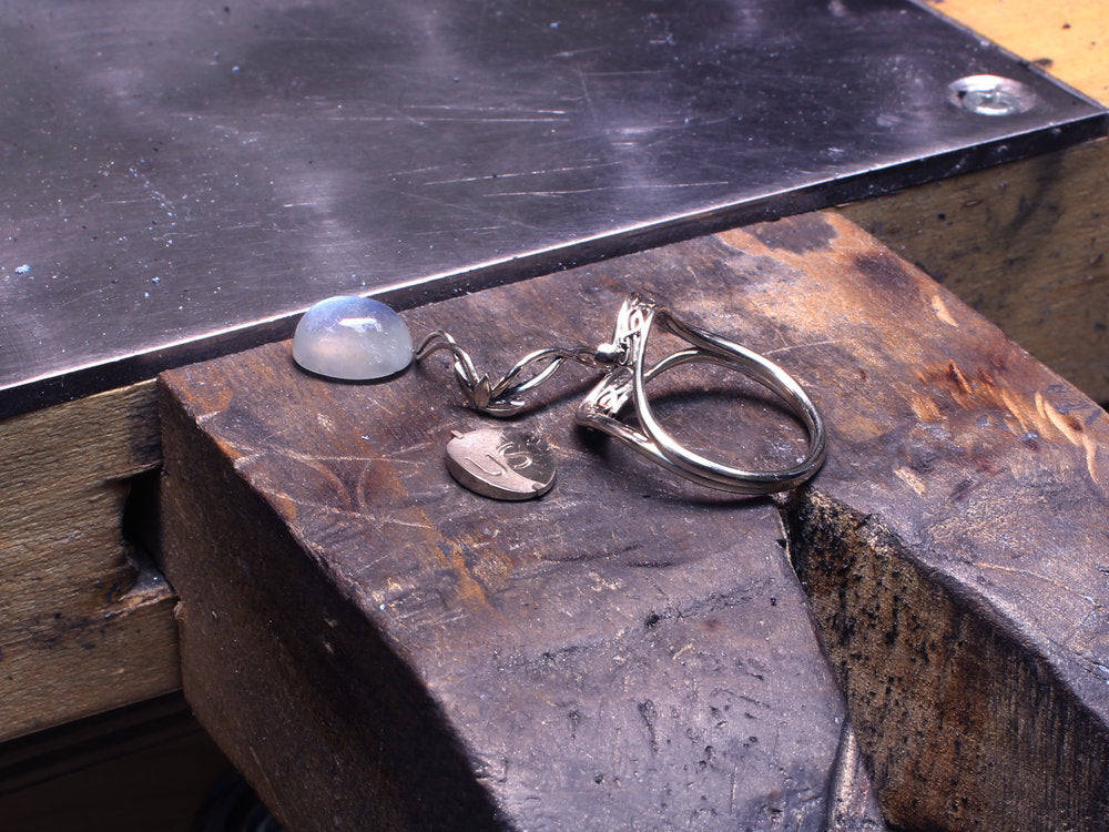 The custom Elvish Moonstone engagement ring on Takayas' workbench