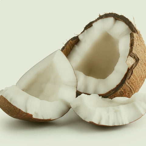 Fresh coconut cut nearly in half, revealing the white meat inside