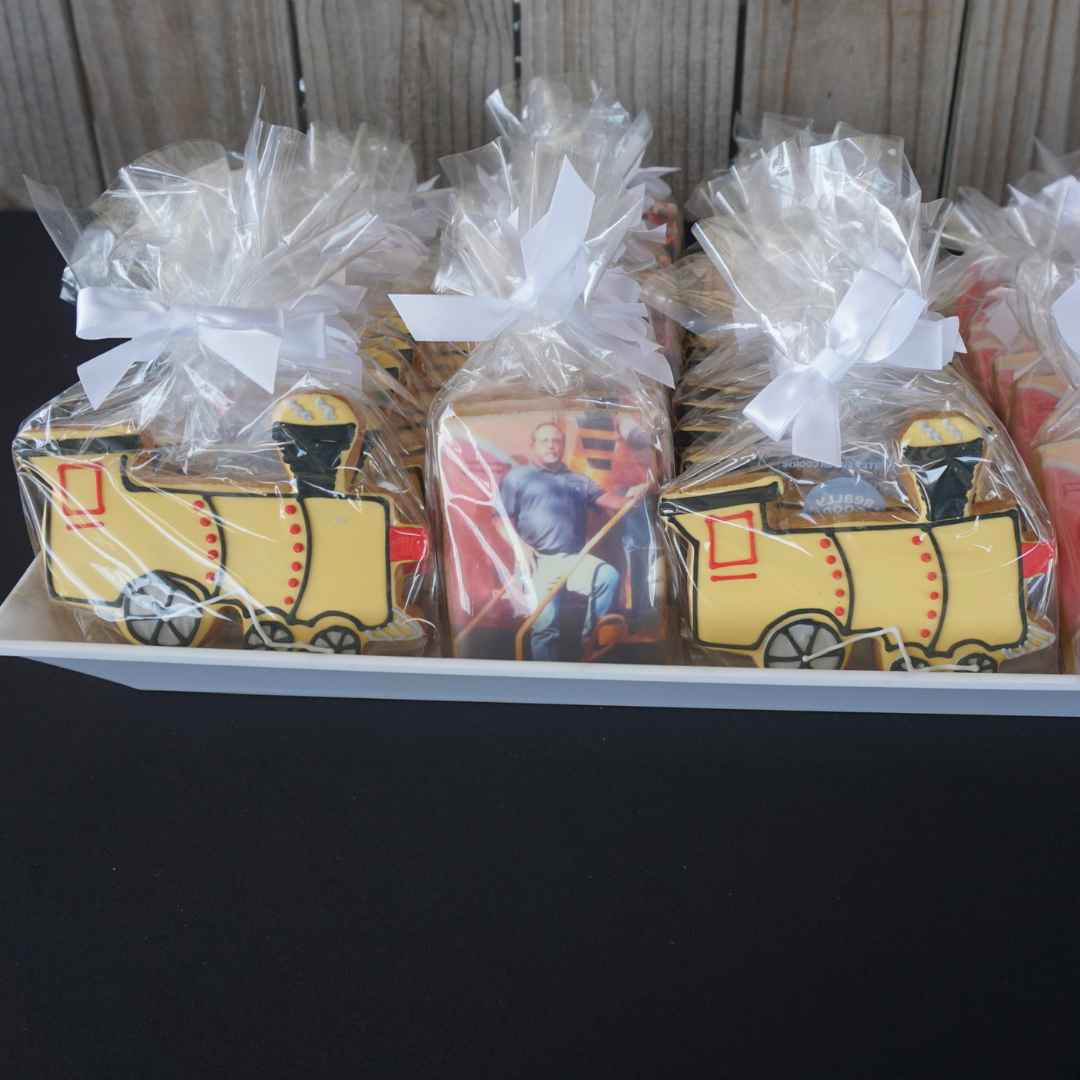 A photo of Really Good Cookie's train Custom Cookies and photo cookies for a retirement.